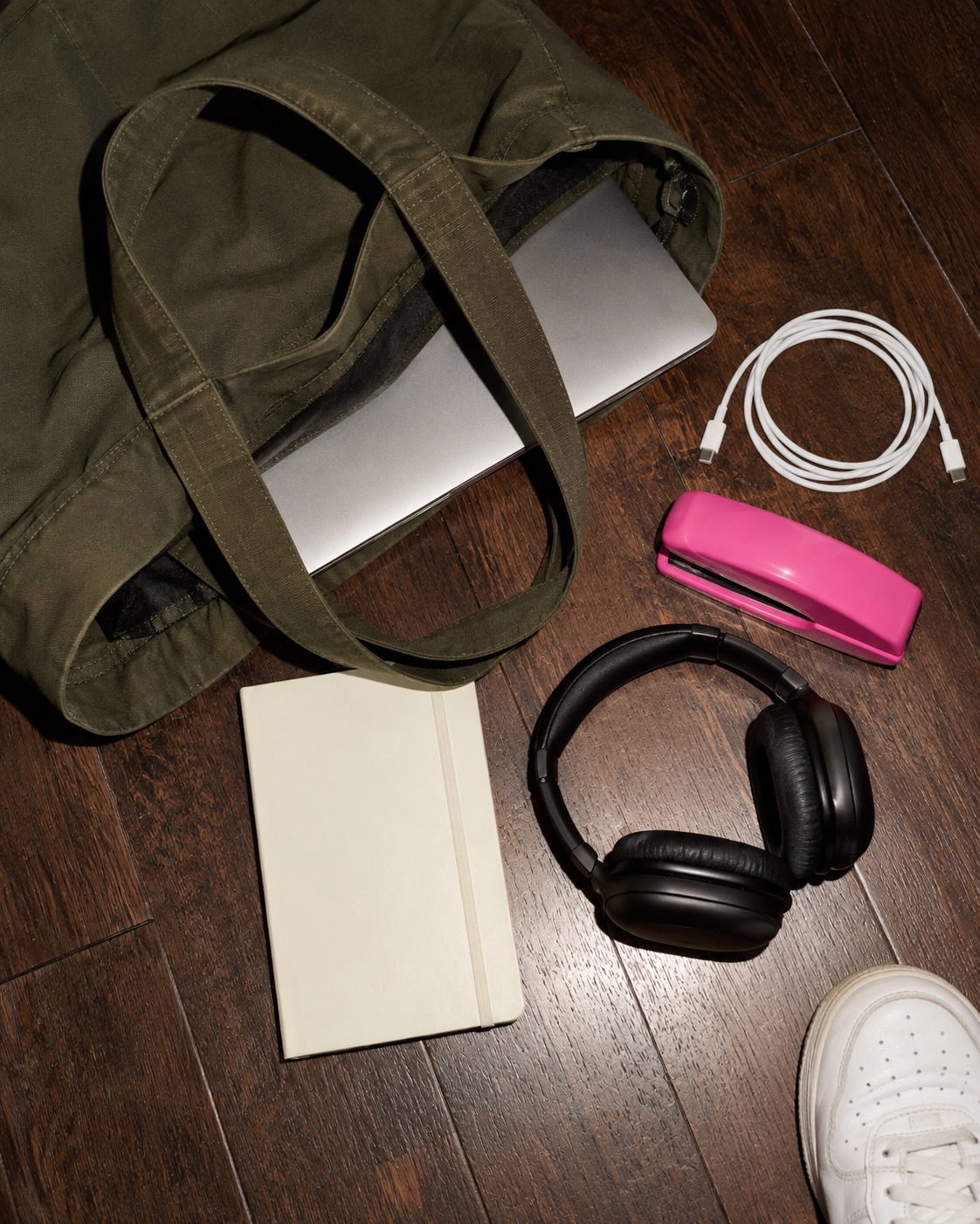 An olive work bag with a laptop and everyday business essentials